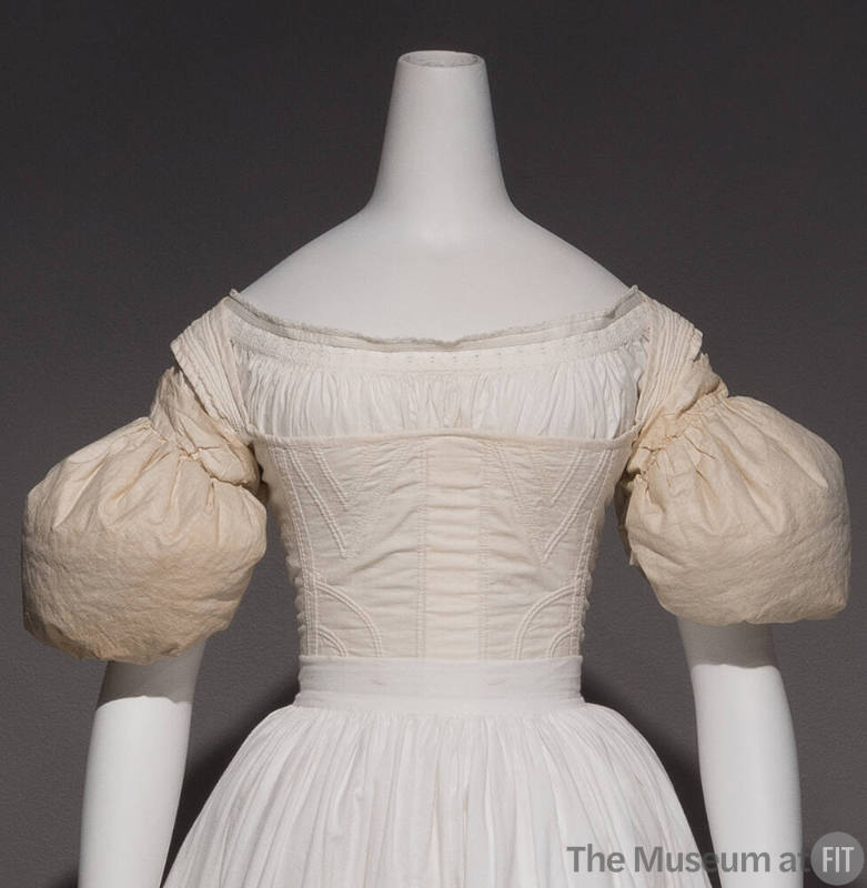 Pair of white sleeve puffs dressed on the upper arms of mannequin with petticoat and corset