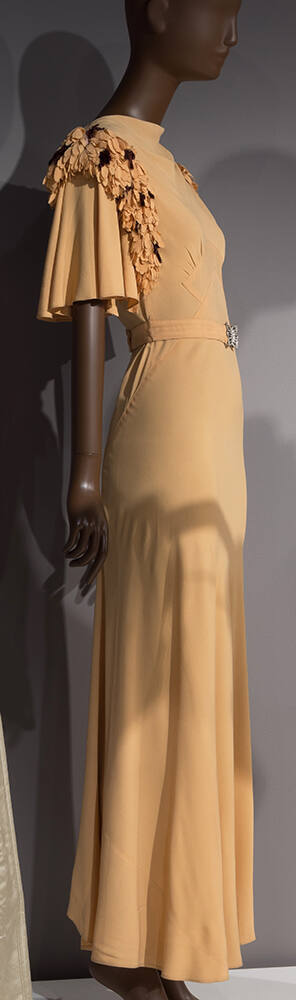 Pale orange floor length bias cut dress with self petals and purple flowers lining armholes, sh…