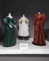 Statement Sleeves exhibition installation view of three mannequins in green, white and red dres…