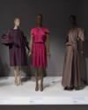 Statement Sleeves exhibition installation view of three mannequins in purple, pink and taupe dr…