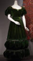 Green velvet floor length dress with short puffed sleeves and off-white lace trim
