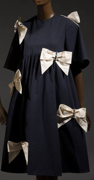 Navy blue knee length tent dress with elbow length bell sleeves, empire waist and large ivory b…