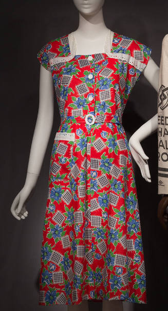 Red sleeveless dress with blue and green floral and black and white check print, white lace tri…