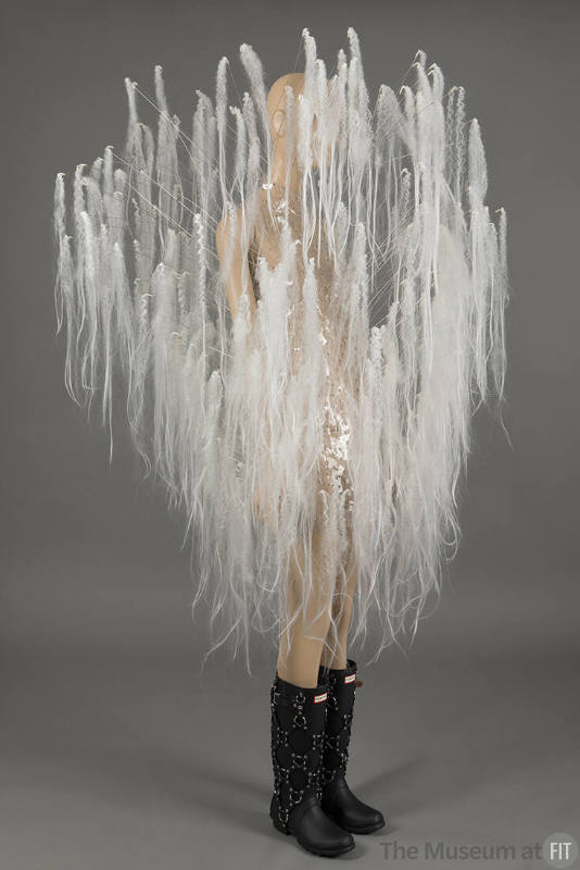 Clear sleeveless mini dress with protruding white hair extensions over the entirety, black rain…