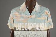 Short sleeve button up shirt with graphic landscape print and text Late Capitalism