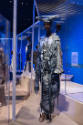 Africa’s Fashion Diaspora exhibition installation view of a mannequin in a grey ensemble with d…