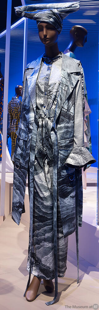 Ensemble of grey shipwreck print: open side jacket with wrap ties, long sleeve shirt with ruffl…