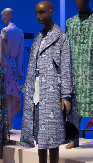 Ensemble of purple and blue print with portrait medallions: shawl collar trench style coat, sna…
