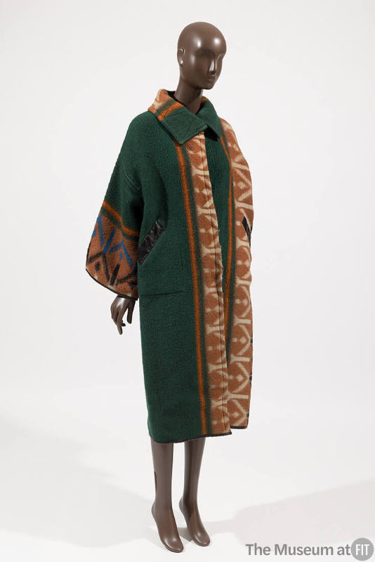 Green coat with vertical orange, white, black and blue geometric designs and oversize collar