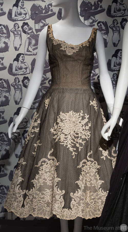 Cream evening dress with black dotted net and cream floral and ribbon designs over top, sleevel…