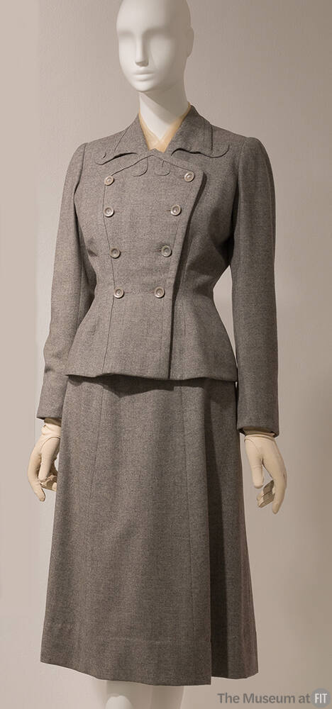 Grey double breasted suit with scroll shaped lapels, fitted waist and knee length skirt