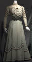 Green dress with white confetti print and alternating rows of lace and black velvet ribbon on b…