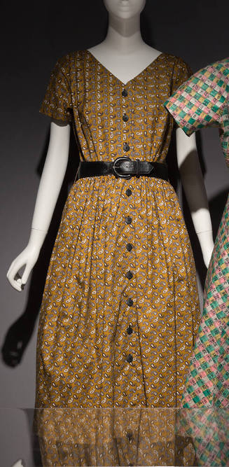 Dark yellow, grey and black paisley printed dress with short sleeves, button front and black be…