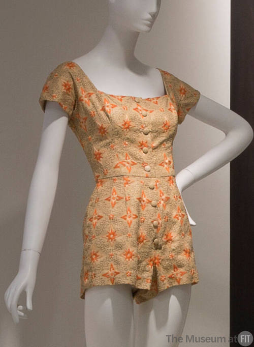 Beige playsuit with orange and black embroidery, cap sleeves and button front