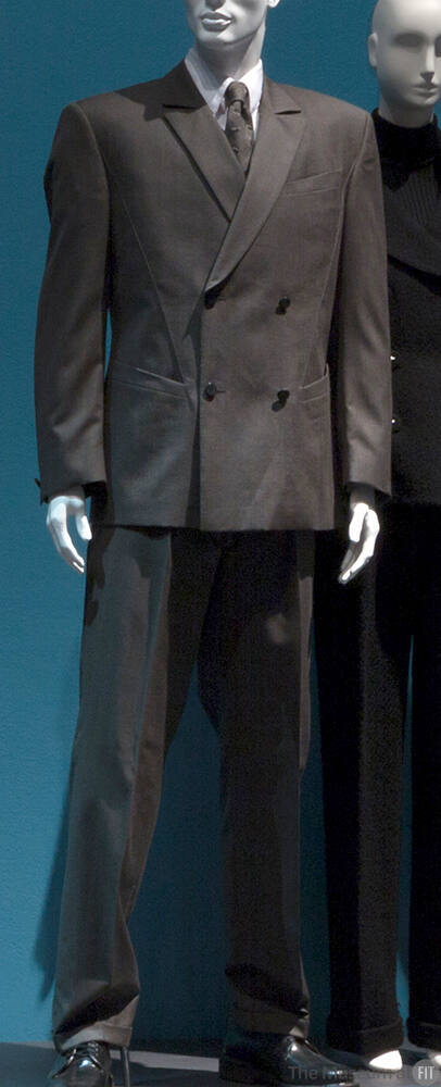 Man’s dark olive green/tan suit, double breasted and straight leg pants with matching tie, whit…