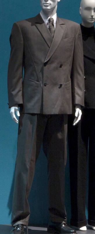 Man’s dark olive green/tan suit, double breasted and straight leg pants with matching tie, whit…