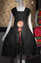 Black knee length dress with large collar meeting at front waist at large multicolor ribbon flo…