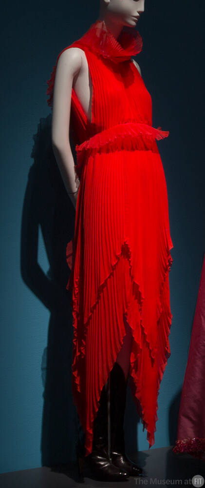 Red pleated halter dress with funnel neck, ruffle waist accent and tiered handkerchief hem and …