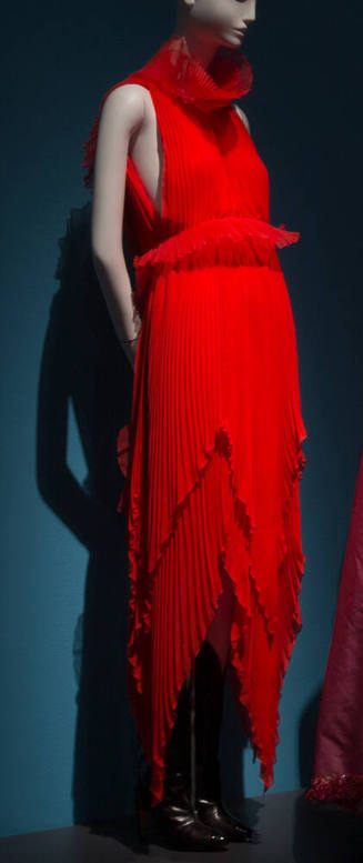 Red pleated halter dress with funnel neck, ruffle waist accent and tiered handkerchief hem and …