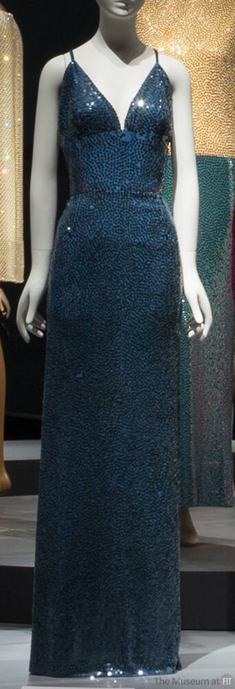 Blue sequined floor length evening dress with deep V-neck and narrow straps