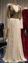 ¾ view of off-white evening gown with gold braid and paillettes