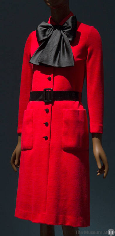 Red knee length shift dress with large black bow scarf, black button front, black belt and fron…