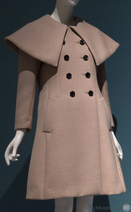 Beige double breasted coat with oversize, pointed cape collar and eight black buttons
