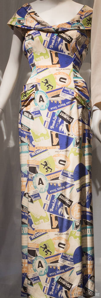 Off-white floor length dress with printed blue, black, ochre and green travel emblems and ticke…