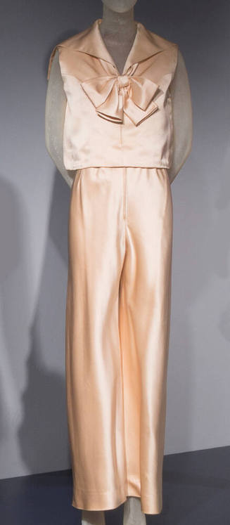Off-white silk satin evening pantsuit of sleeveless blouse with wide sailor collar and large bo…