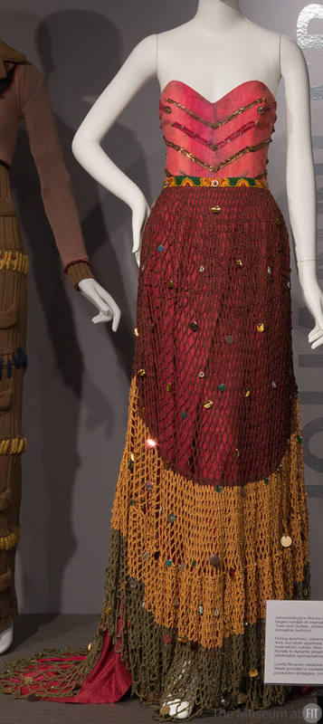 Red strapless floor length dress with beaded V shaped bands on bodice, green and yellow fishnet…