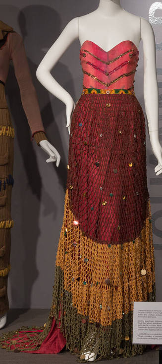 Red strapless floor length dress with beaded V shaped bands on bodice, green and yellow fishnet…