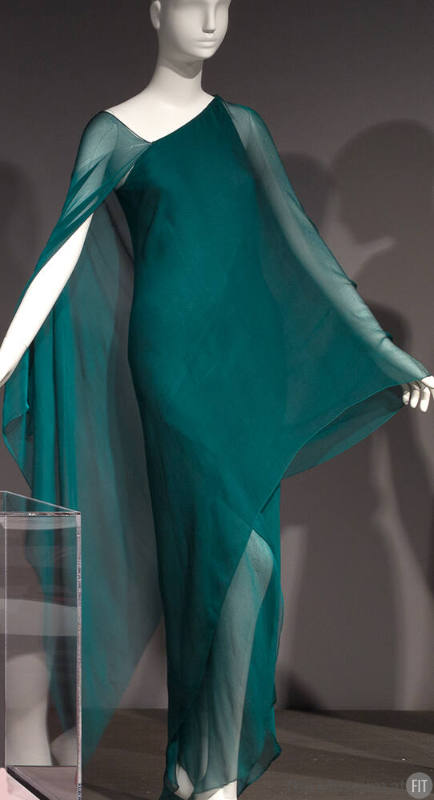 Teal green one shoulder evening dress in layers of silk chiffon, wrap style over arms creates a…