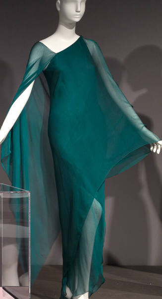 Teal green one shoulder evening dress in layers of silk chiffon, wrap style over arms creates a…