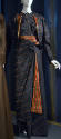 Black evening ensemble with small coral and gold pinwheel dot pattern of blouse, short open jac…