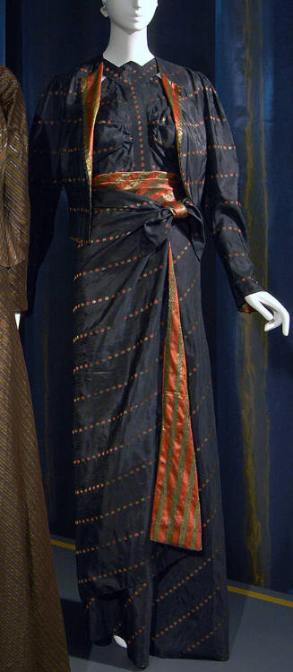 Black evening ensemble with small coral and gold pinwheel dot pattern of blouse, short open jac…