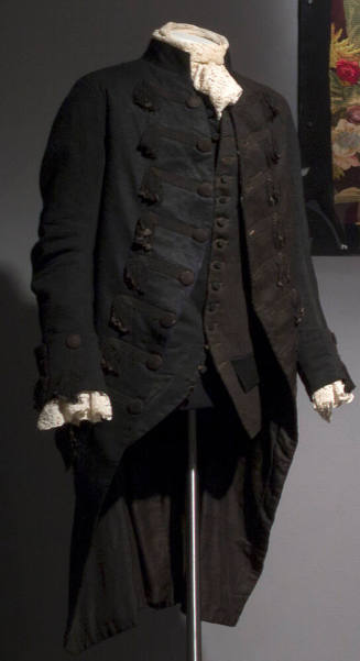 Man’s black livery jacket with braid frogging front closure with buttons, calf length back, but…