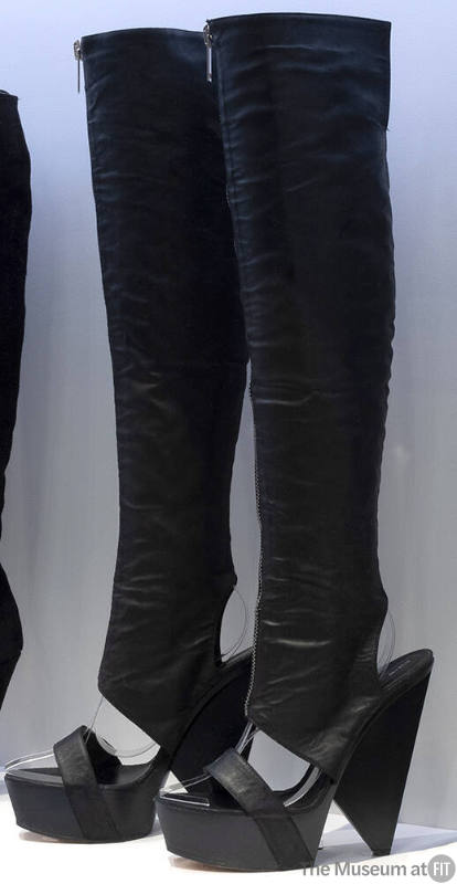 Pair of black thigh high platform wedge boots with sandal style single strap across open vamp, …