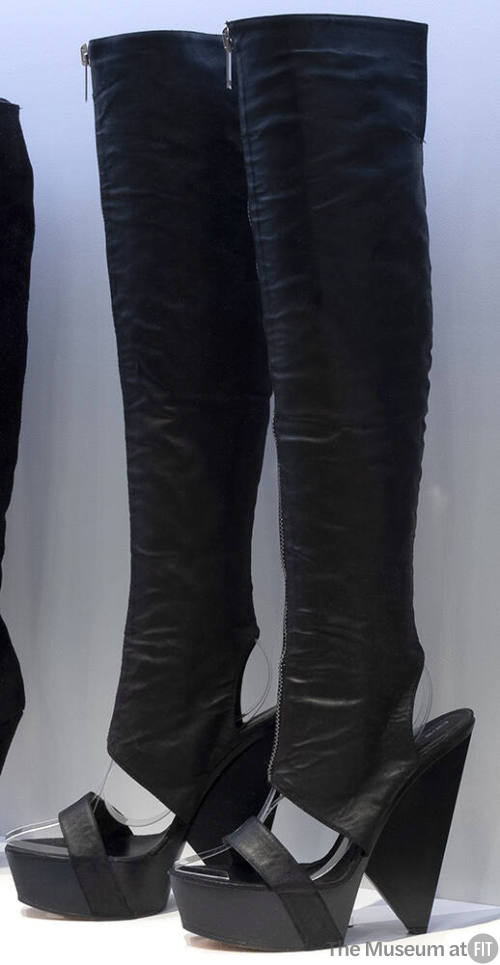 Pair of black thigh high platform wedge boots with sandal style single strap across open vamp, …