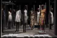 Fashioning Wonder exhibition installation view of seven dressed mannequins in front of mirrors …