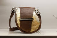 Close up view of an oyster shell and brown leather bag in the “Specimens” case of the Fashionin…