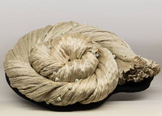 Pale green pleated dress accented with beads twisted and coiled in a spiral