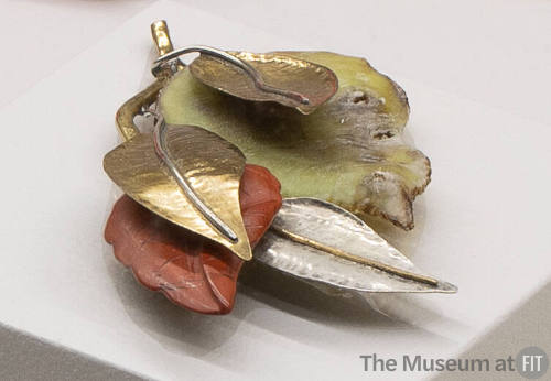 Dimensional pin of leaves in gold and silver metal and green and rust enamel 