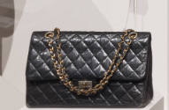 Black quilted leather envelope handbag with swivel clasp closing on front flap and gold chain s…