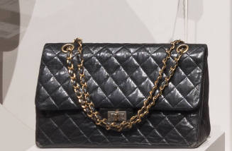 Black quilted leather envelope handbag with swivel clasp closing on front flap and gold chain s…