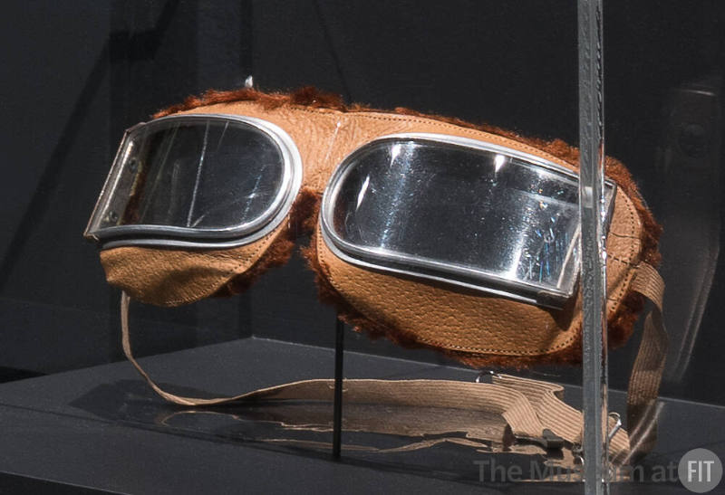 Motoring goggles with semi-rectangular lenses set in tan leather frame edged in brown chenille …