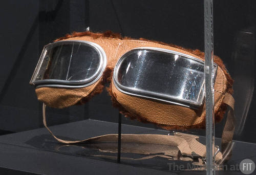 Motoring goggles with semi-rectangular lenses set in tan leather frame edged in brown chenille …