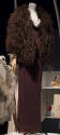 Brown jersey floor length gown with cowl neckline and brown feathered cape with elbow length sl…