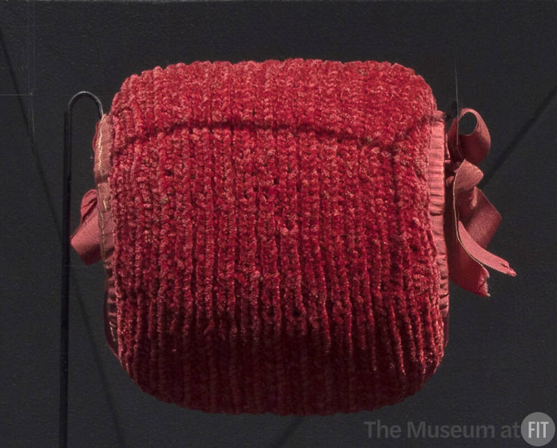 Knit pink chenille muff edged in grosgrain ribbon and bows at either end