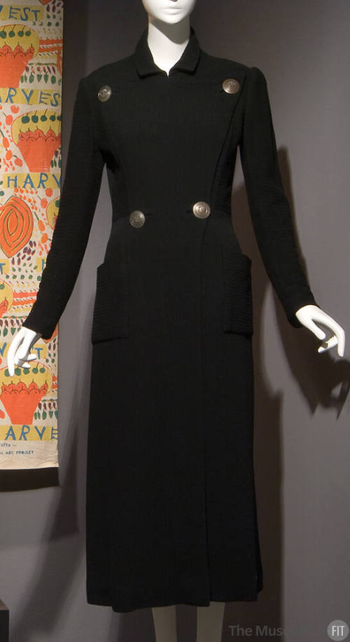Black fitted double breasted coat with four large silver buttons and two patch pockets on hips
