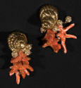 Pair of gold metal earrings in the shape of spiral seashells with attached clusters of orange/r…